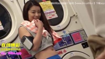 单独与一名美丽的妇女在硬币洗衣店的轻的衣裳的第3部分